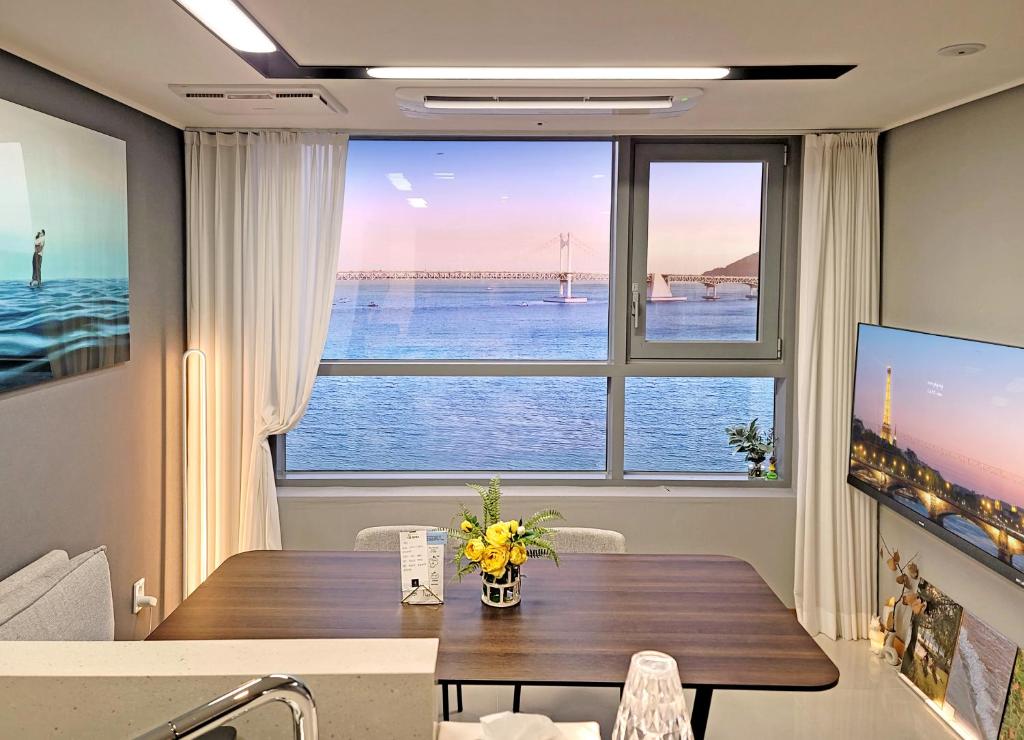 a dining room with a table and a large window at 오늘도광안씨 in Busan