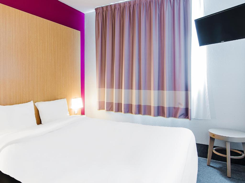 een hotelkamer met een bed en een raam bij B&B HOTEL Toulouse Basso Cambo in Toulouse