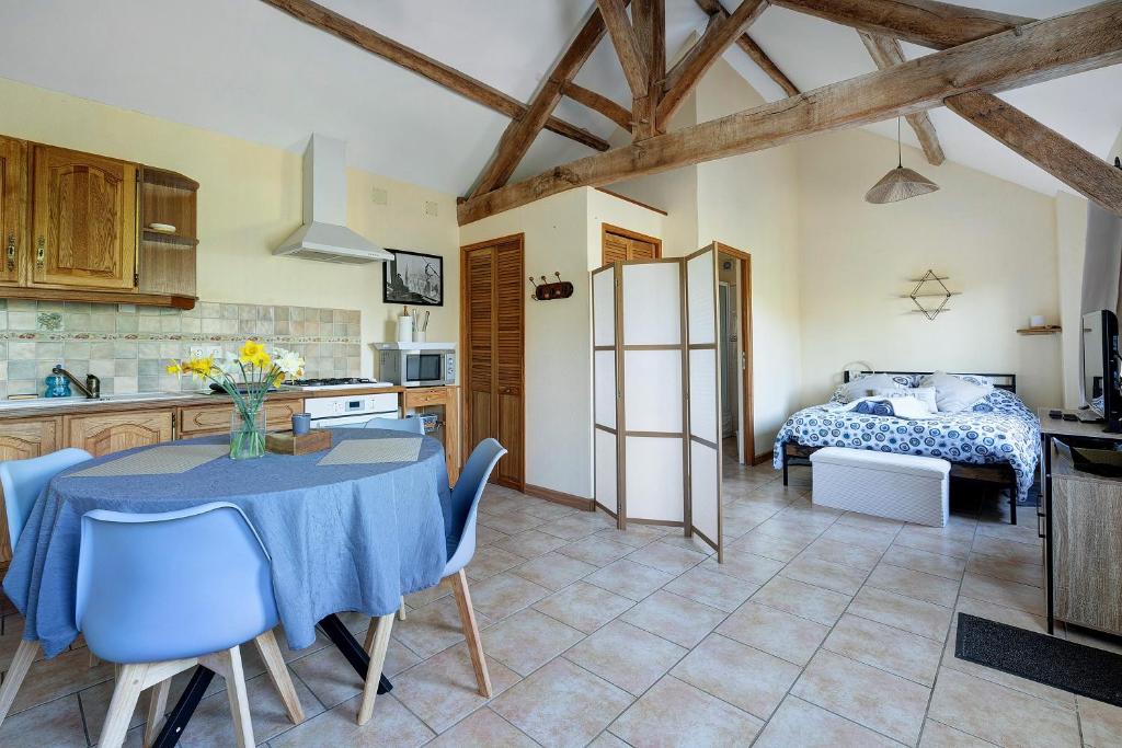 a kitchen and dining room with a table and a bed at Gîte Chemin Des Hêtres in Armaillé