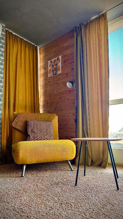 a yellow couch and a glass table in a room at Smart apartment -Має Резервне живлення in Yuzhne
