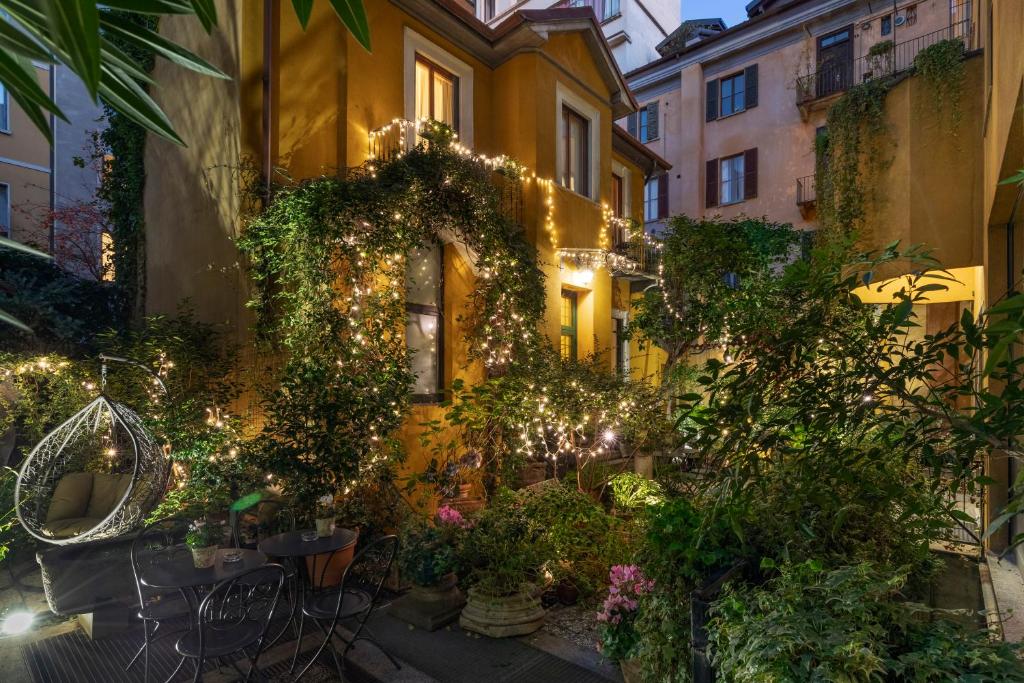 a building with a lot of plants and lights at Hotel Sanpi Milano in Milan
