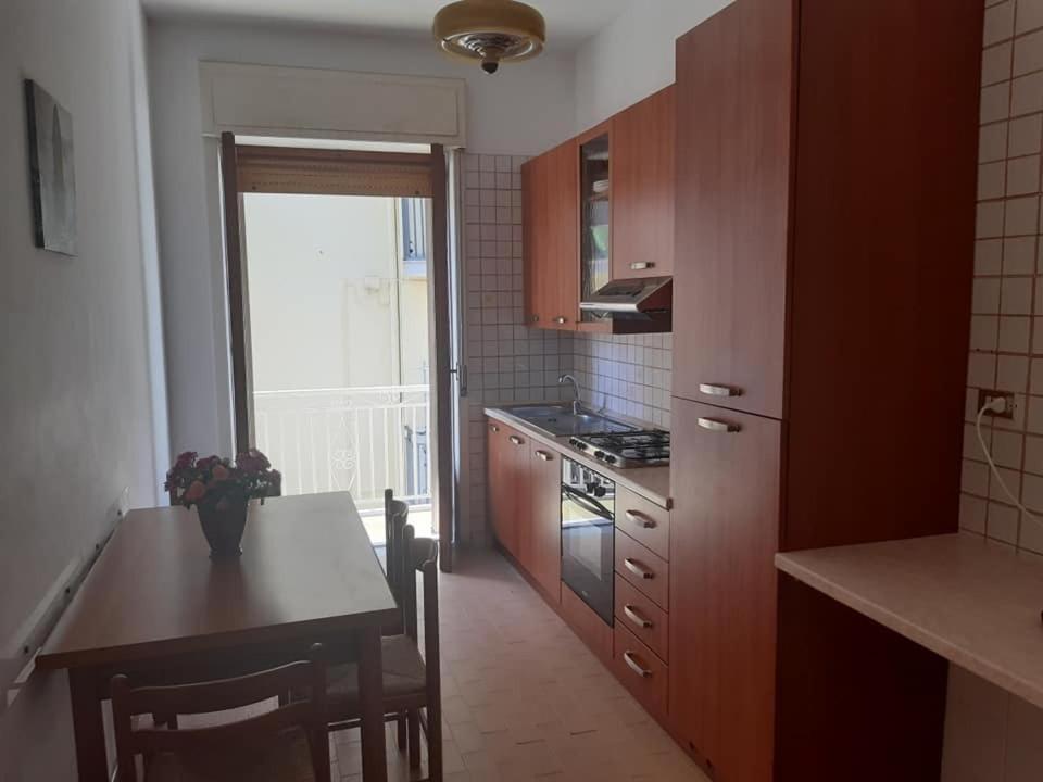 a kitchen with wooden cabinets and a table and a kitchen with a stove at Appartamento Serenity in Marina di Ascea