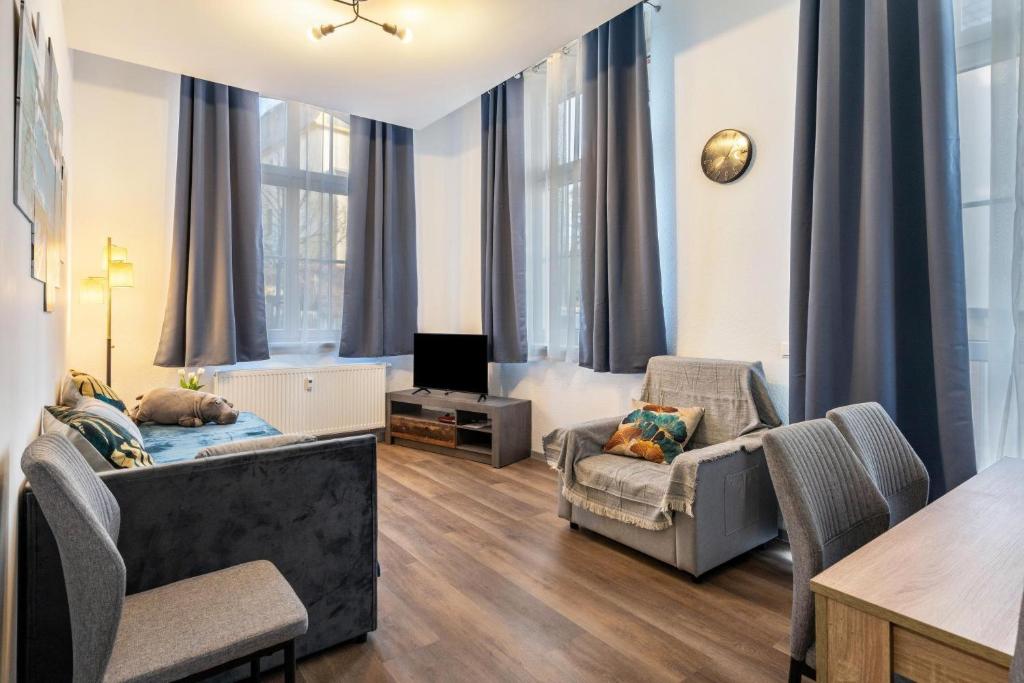 a living room with a couch and chairs and a tv at murihaus Ferienwohnung 2 in Aue