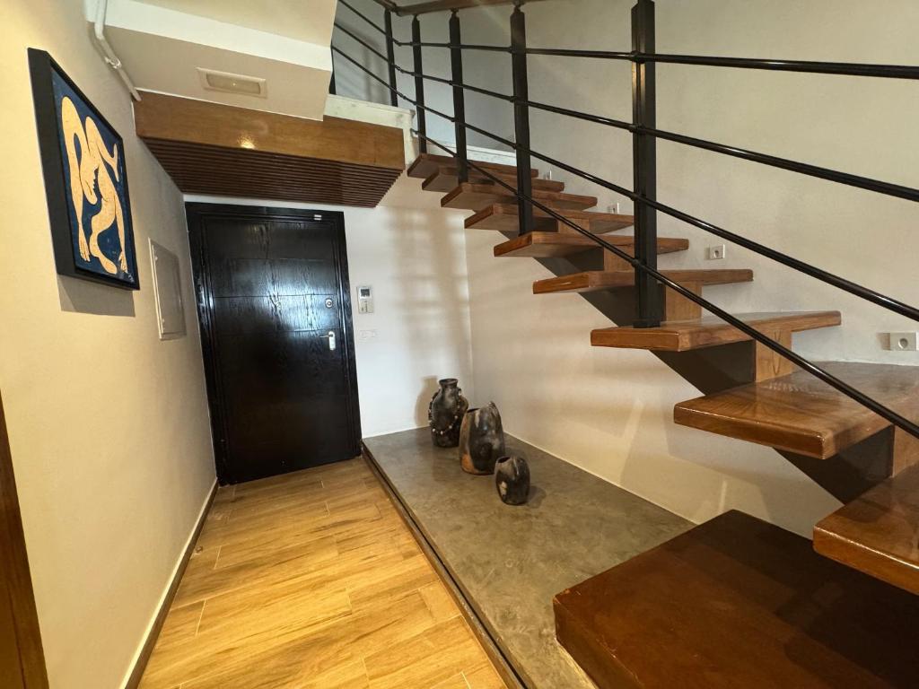 a hallway with a staircase with a black door at SKYLINE SUITES Tunisia in Tunis
