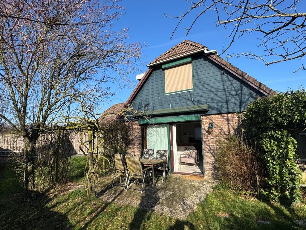 a house with a table and chairs in the yard at Vakantiewoning bij het Veerse Meer in Wolphaartsdijk