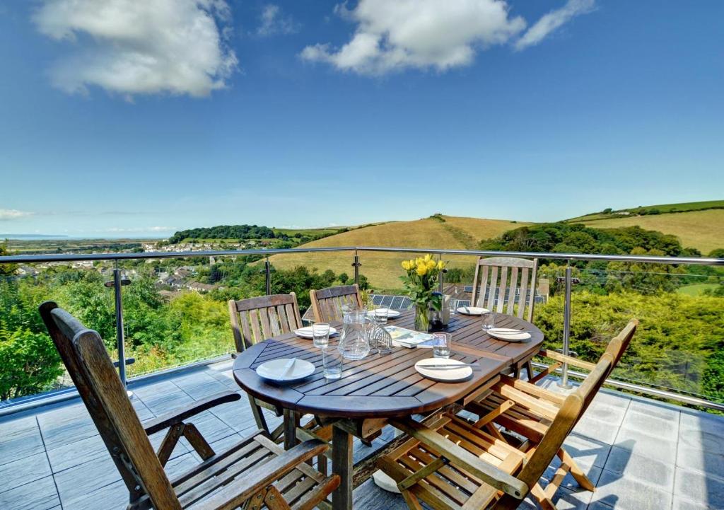 a wooden table and chairs on the balcony of a house at 3 Bed in Braunton oc-ashb in Braunton
