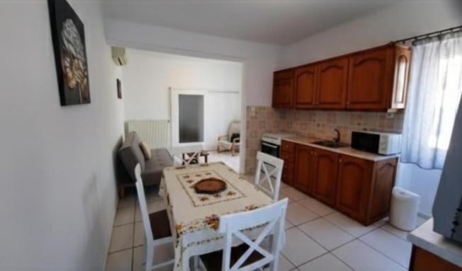 a kitchen with a table and chairs in a kitchen at Aegina house1 in Egina