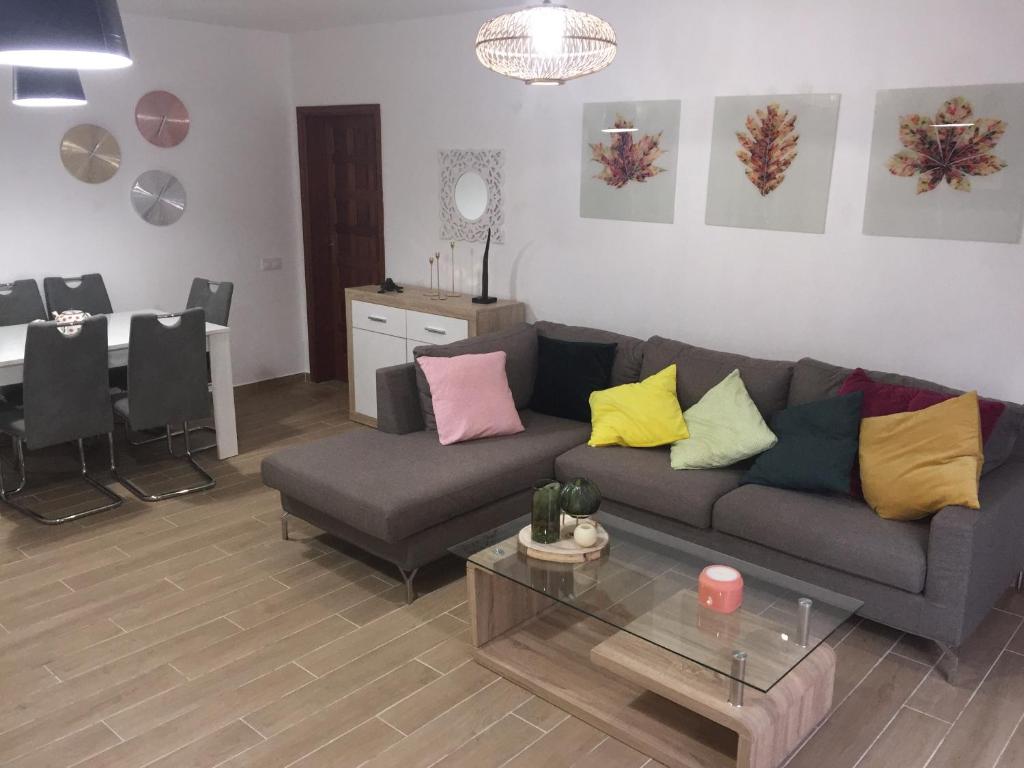 a living room with a couch and a table at Casa Corralejo a 40 m playa in Corralejo