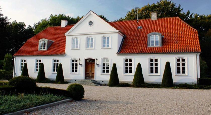 une maison blanche avec un toit orange dans l'établissement Louiselund Bed & Breakfast, à Haderslev