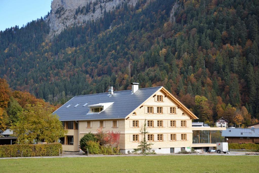 a large house in front of a mountain at Hotel Tannahof in Au im Bregenzerwald