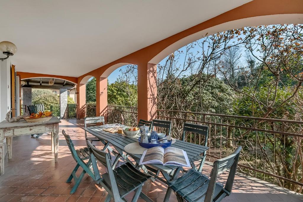 a patio with a table and chairs on a balcony at Villa Eva: Leggiuno 5-Bed Villa for Families & Groups (Sleeps 10) - Happy Rentals in Leggiuno
