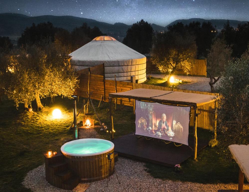a yurt with a tub and a tv in the yard at 2 CUORI E 1 YURTA Glamping in Tuscany - Adults Only in Asciano
