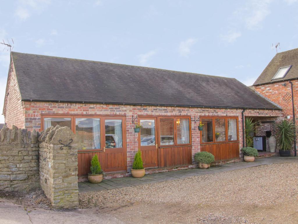 a brick house with windows and plants in front of it at Herdwick Cottage in Much Wenlock