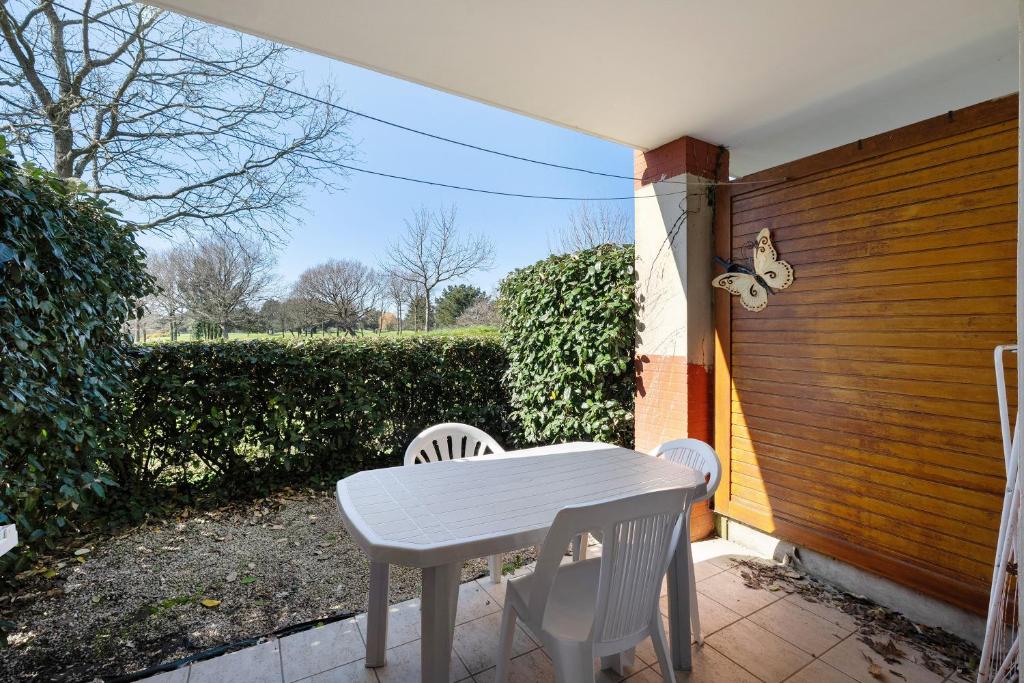 a white table and chairs on a patio at Appartement Du Golf - Pornic 1 in Pornic
