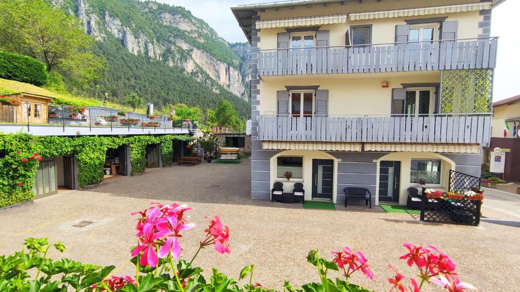 a building with a balcony and flowers in front of it at Apartments Giovannini in Fai della Paganella
