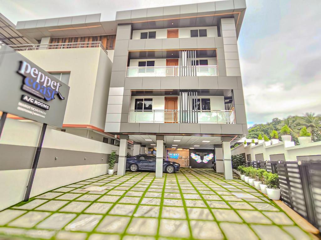 a building with a car parked in the driveway at Pepper Coast Luxury Business Hotel in Cochin