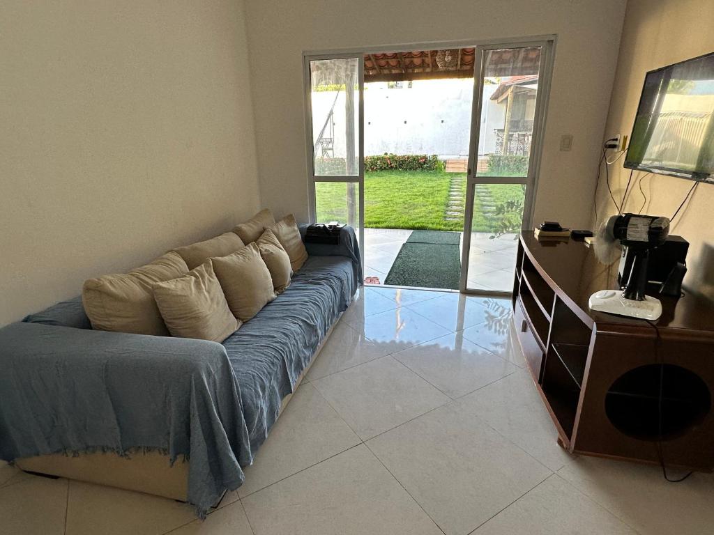 a living room with a couch in front of a sliding glass door at Casa Verano dHebron in Camaçari