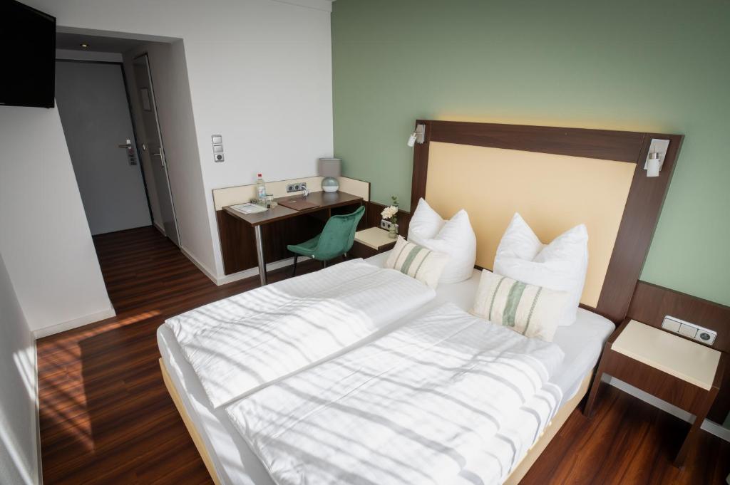 a hotel room with a large bed and a desk at Gästehaus am Räuschenberg in Höxter