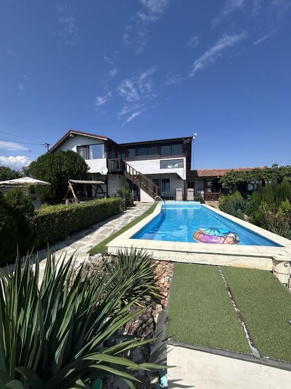 a swimming pool in front of a house at Heaven's Home in Topola