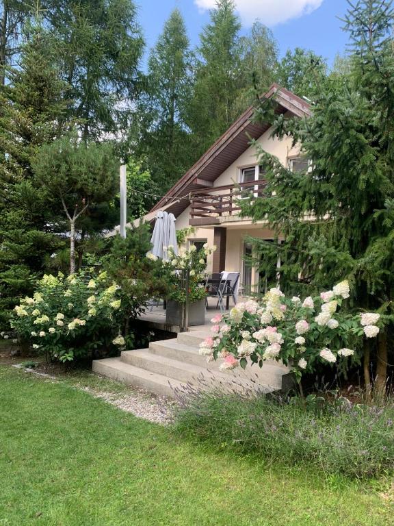 a house with stairs and flowers in front of it at Mazurska Riwiera in Dabrowa