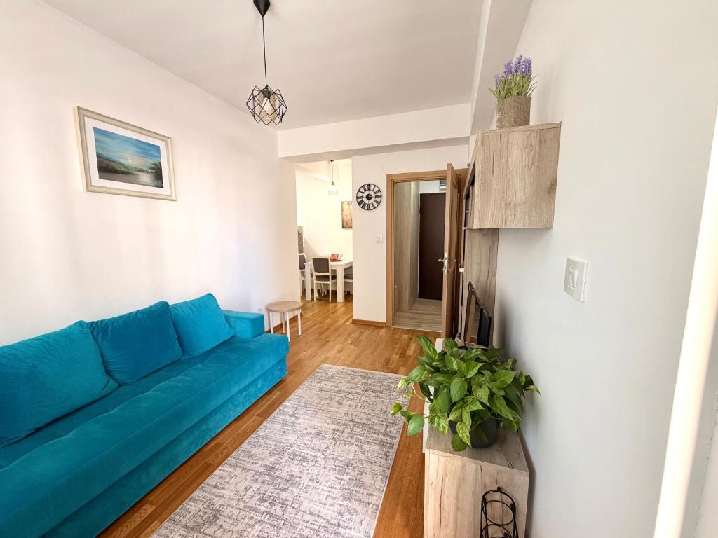 a living room with a blue couch in a room at Odmor u Podgorici. in Podgorica