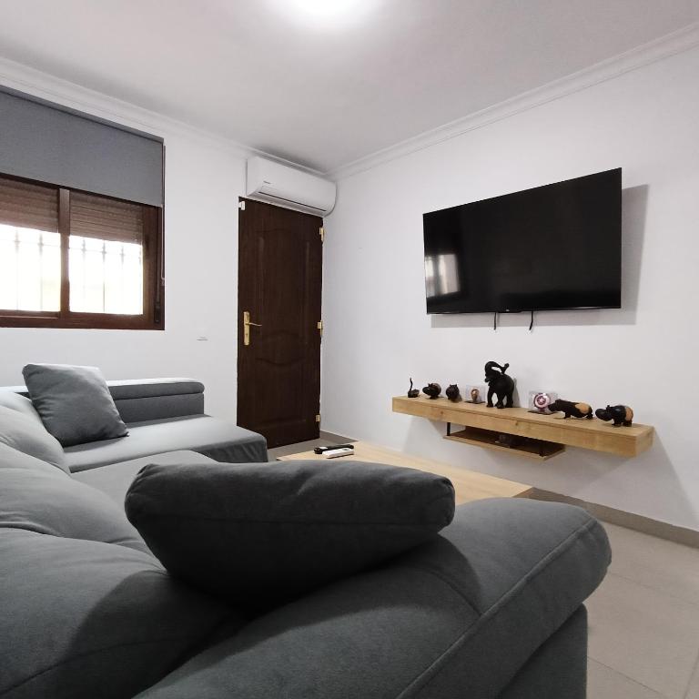 a living room with two couches and a flat screen tv at Casa Lolo in Algodonales