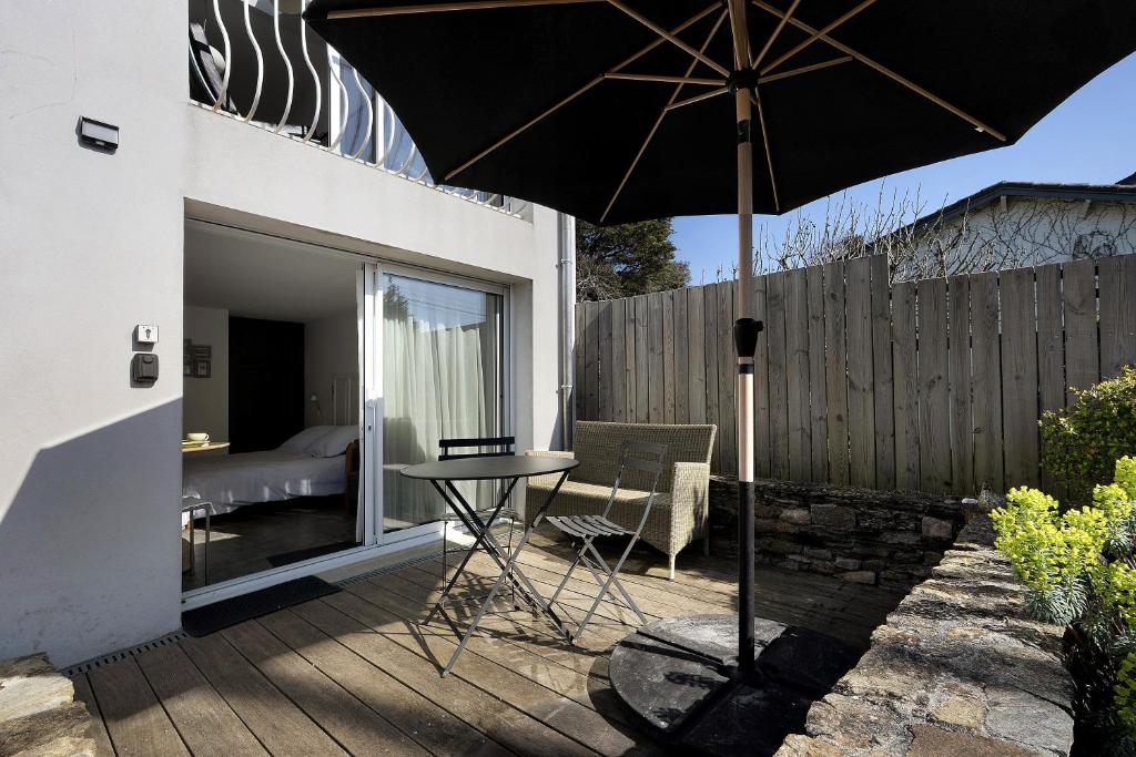 a patio with a table and an umbrella at Chambre D'hôtes Toi Et Moi - in Pornic