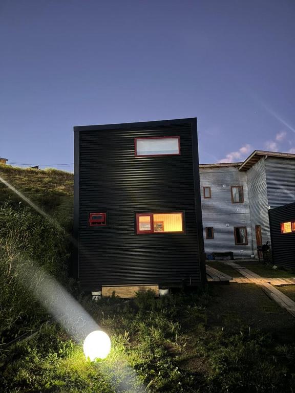 a black house with windows on the side of a building at Stone Tiny Chalten Nordic Cabin Patagonia - Arg in El Chalten