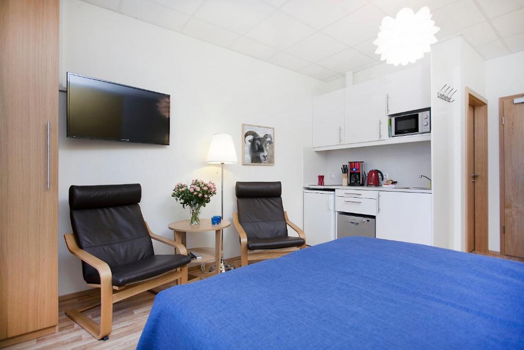 um quarto com duas cadeiras e uma cama e uma cozinha em Northern Comfort Apartments em Reiquiavique