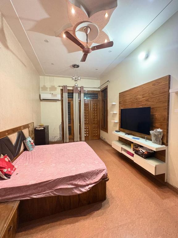 a bedroom with a bed and a flat screen tv at Karshni Kuteer in Mathura