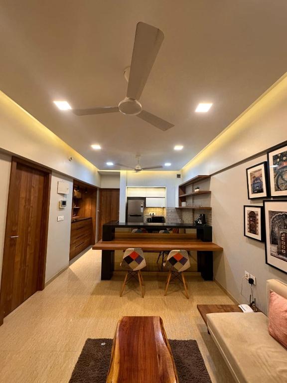 a living room with a table and a kitchen at Skyline Serenia 23rd floor in Dehu Road