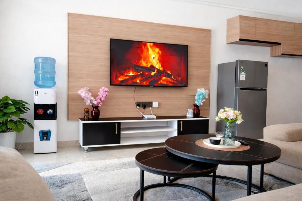 a living room with a fire on the wall at Little Haven Stays-Near UN & Two Rivers in Ruaka
