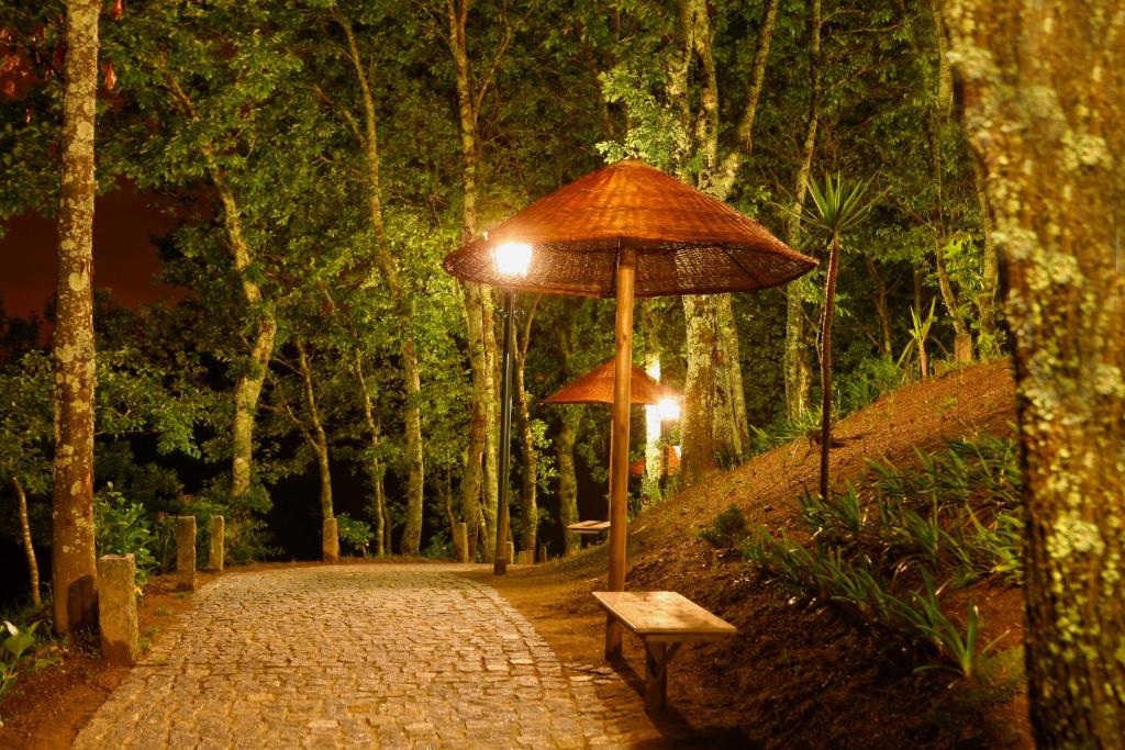 a bench and an umbrella on a path at Quinta da Costa in Lixa