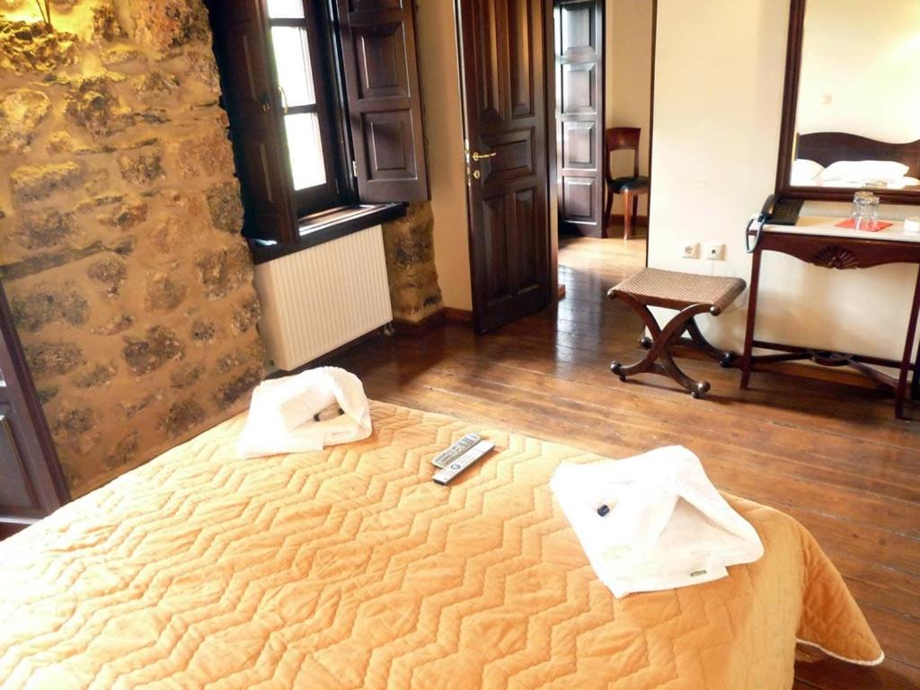 a bedroom with a bed with two towels on it at Ξενώνας Αρχοντικό Πρεδάρη in Goura