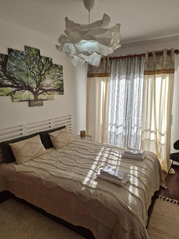 a bedroom with a large bed and a chandelier at LandS in Caniço