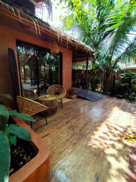 a porch with a wooden deck with chairs and a table at Terracotta tropical nest in San Vicente