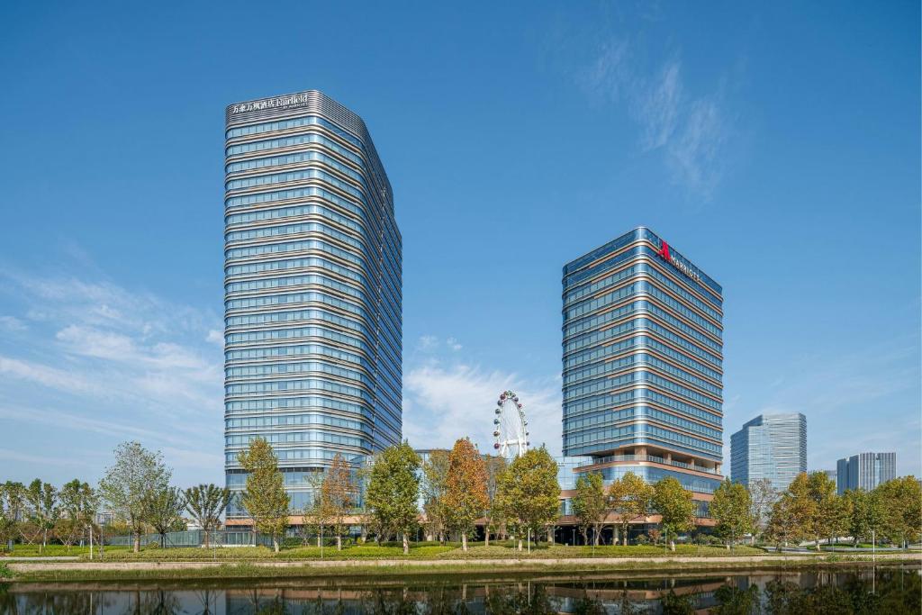 two tall buildings in a city next to a river at Fairfield by Marriott Deqing in Huzhou