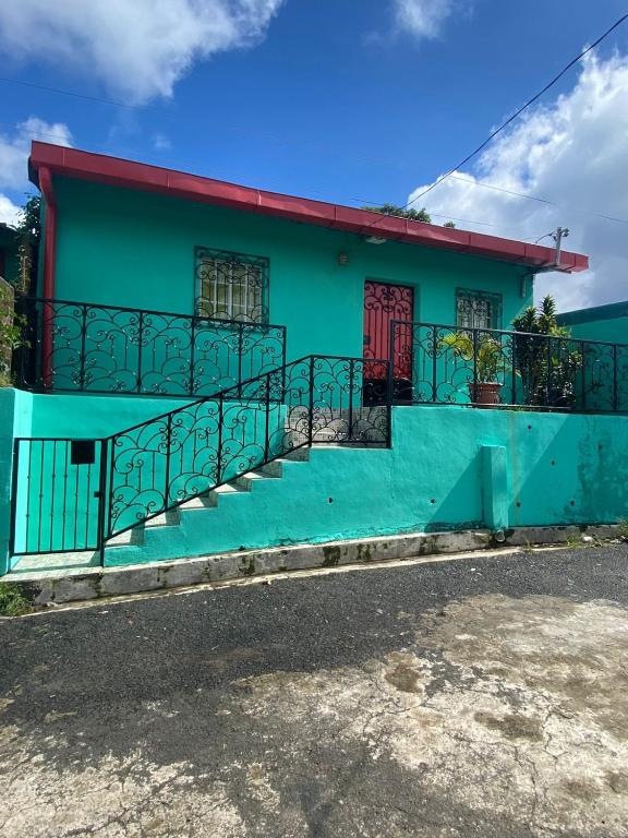 a green building with a staircase in front of it at Abril hospedaje in Juayúa