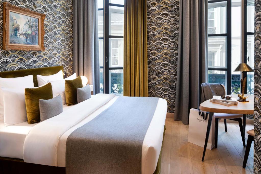 a hotel room with a large bed and a table at Hotel Pas De Calais in Paris