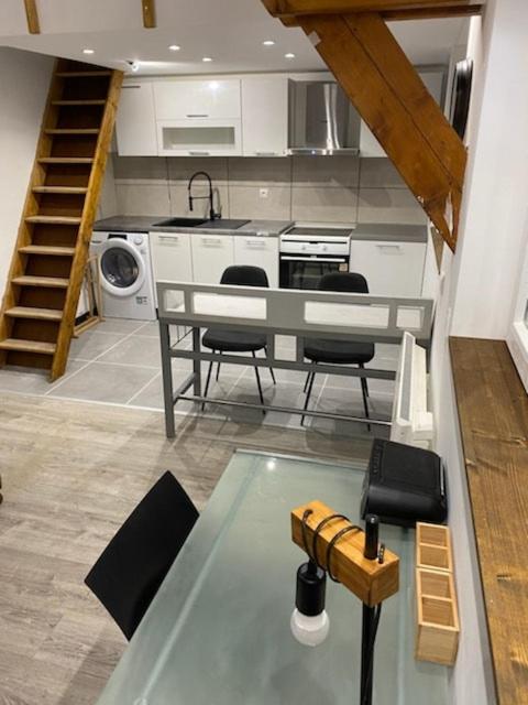 a kitchen with a table and some chairs in it at Logement Sierentz proche aéroport in Sierentz