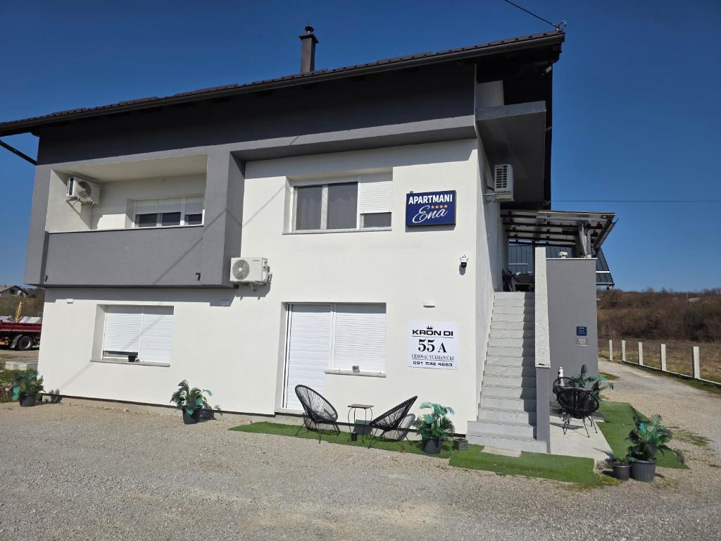 a white house with two chairs in front of it at ENA 1&2 apartments-free parking 2200 m2-truck,trailer,boats friendly-EASY D1 access in Karlovac