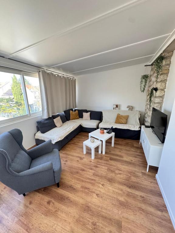 a living room with a couch and a table at Large house with garden in Vulaines-sur-Seine
