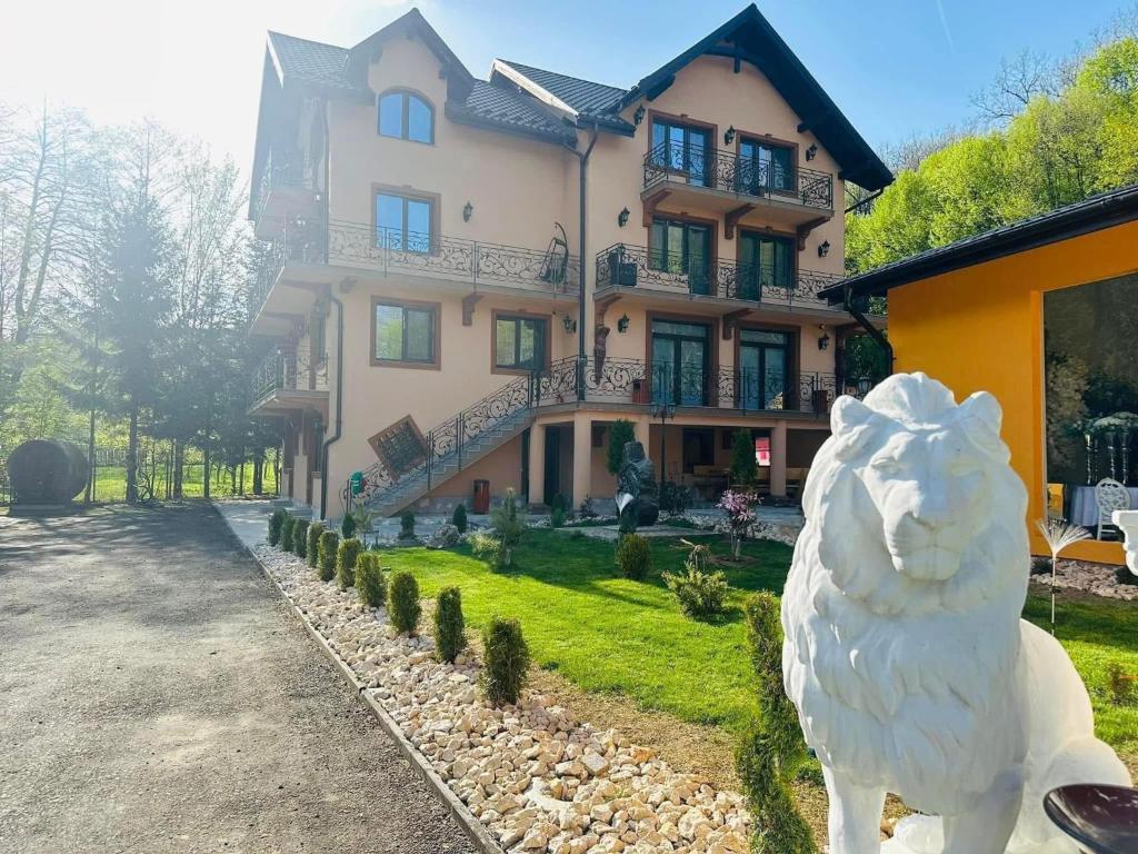a large house with a statue of a sheep in front of it at Imperial Resort in Codlea