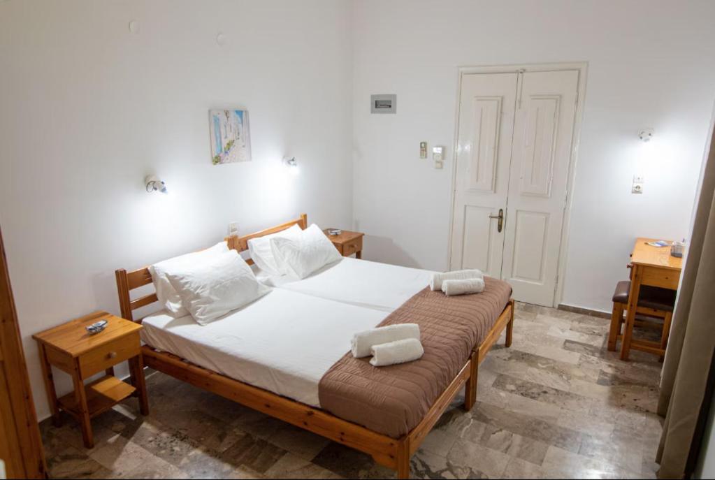 a bedroom with a bed with two towels on it at Anemone Masouri in Masouri
