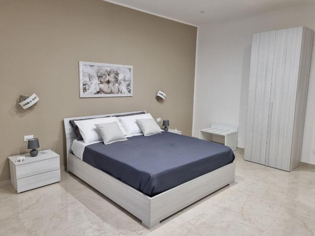 a bedroom with a large bed with a blue bedspread at ASTRA Guest House in Taranto