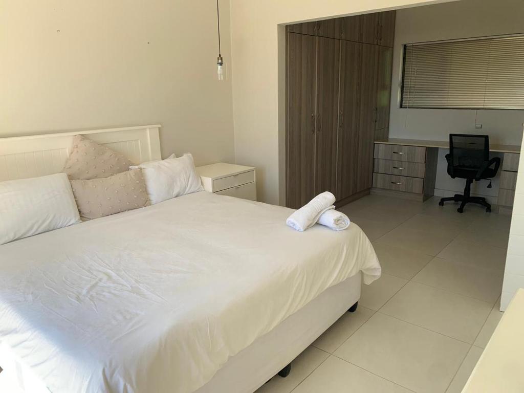 a bedroom with a white bed and a desk at Villa Ti Amo Flat in Ramsgate