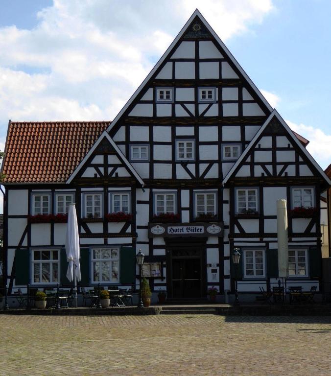 a large black and white building with an umbrella at Hotel Büker in Erwitte
