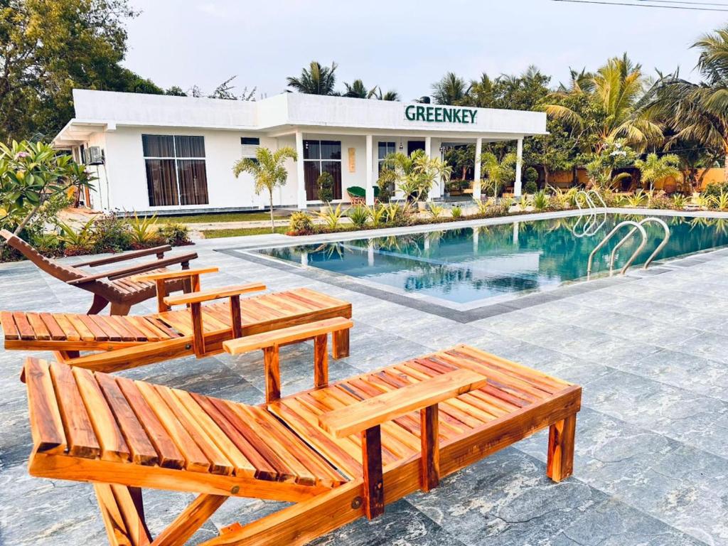 a resort with wooden benches and a swimming pool at GreenKey Hotel & Resturent in Tanamalwila