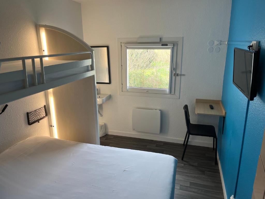 a bedroom with a bed and a desk and a window at Unisotel Bollène A7 Ex-Hotel F1 in Bollène