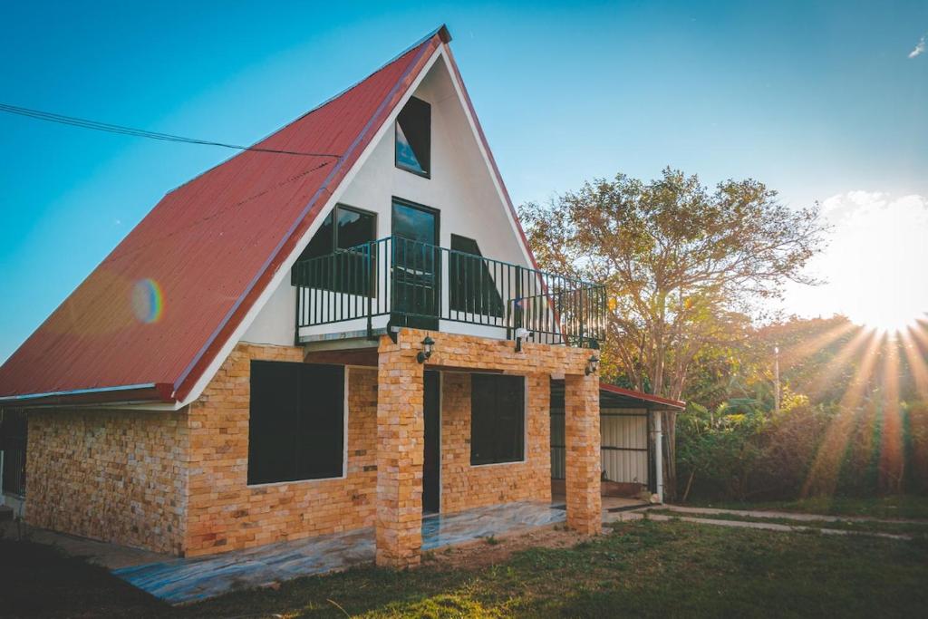 a house with a red roof and a balcony at Calle del Tigre Chalet in Sabana Redonda